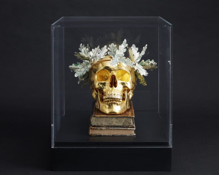 Gilded human skull sculpture with oak leaf wreath